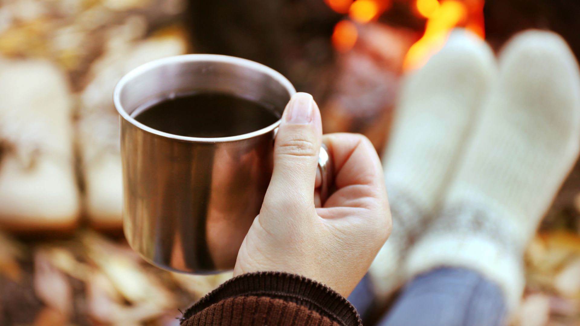 Entspannter Moment mit einer Tasse Kaffee am Feuer als Teil eines bewussten Frequenzerlebnis Rituals